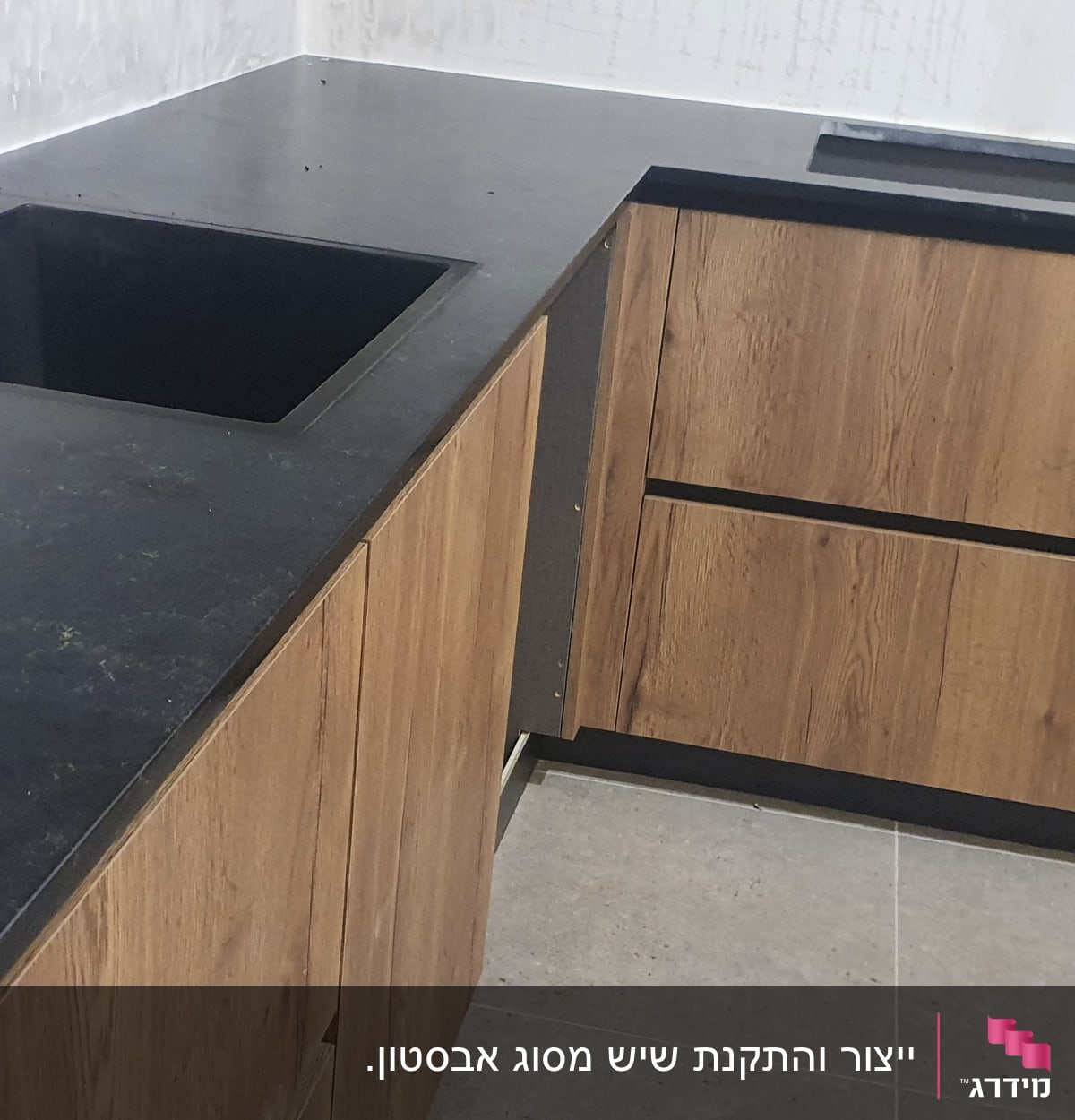 משטח שיש כהה עם כיור מובנה במטבח מודרני